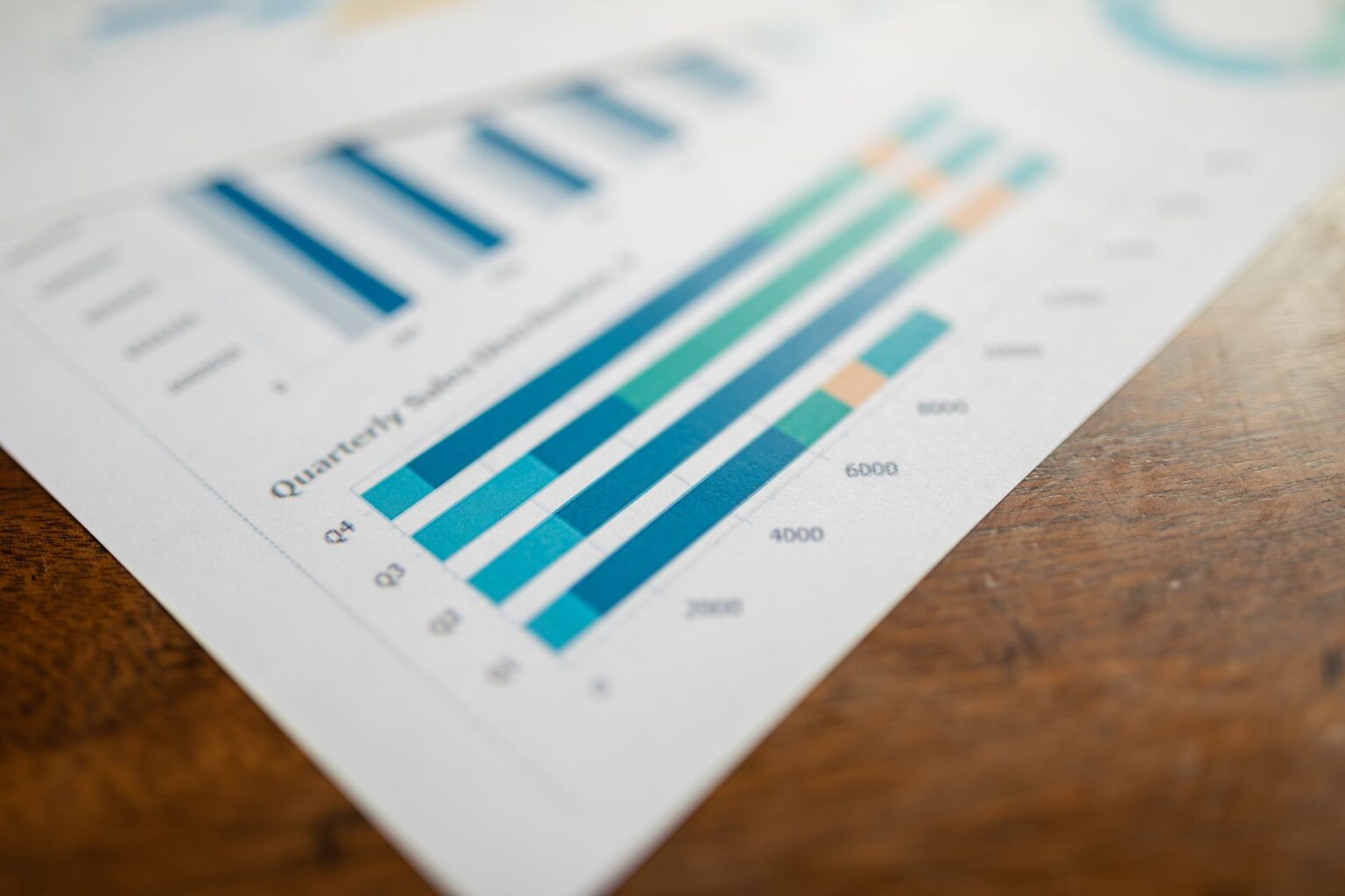Relatório trimestral de vendas com gráfico de barras sobre a mesa, usado para projeção de pipeline. Foto de RDNE Stock project via Pexels.